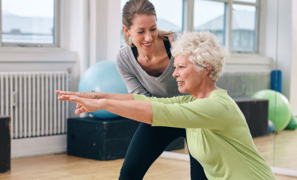 elderly women doing exercise with her personal trainer